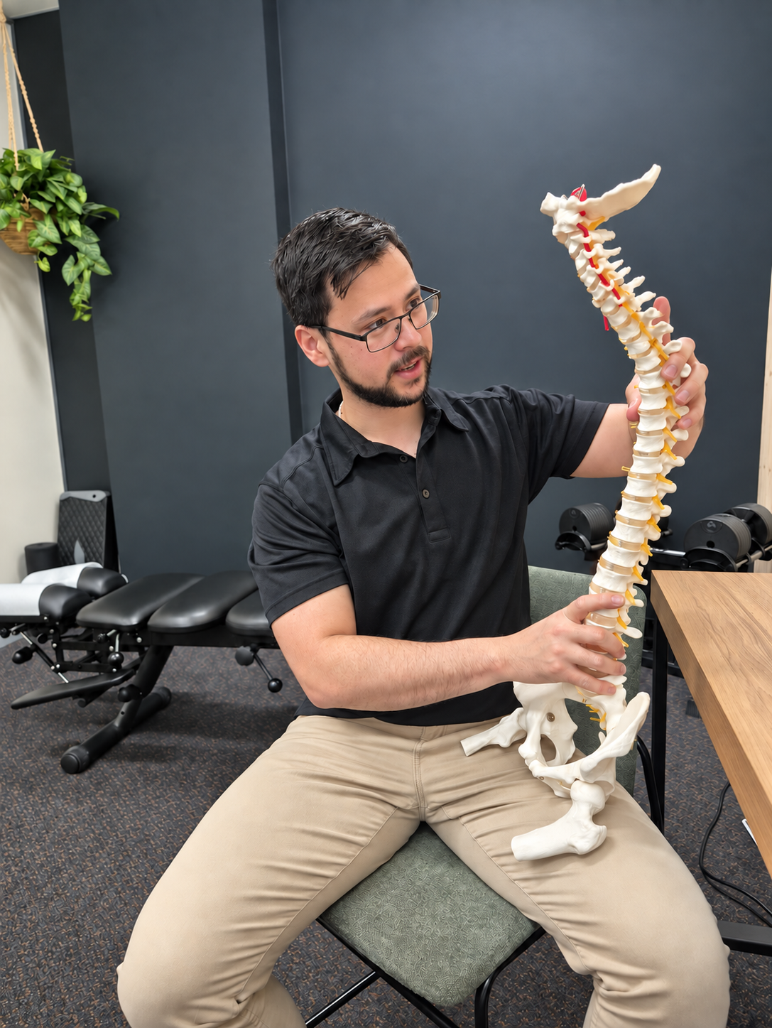 Tehan explaining findings using a spine model at Momentum Health & Function